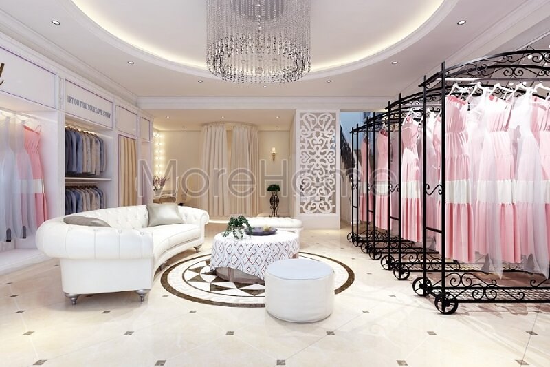 Thiết kế nội thất showroom áo cưới Calla Lily cao cấp với sự có mặt của bộ sofa da màu trắng cùng với thanh treo quần áo màu đen tạo điểm nhấn nổi bật cho không gian căn phòng sofa tân cổ điển